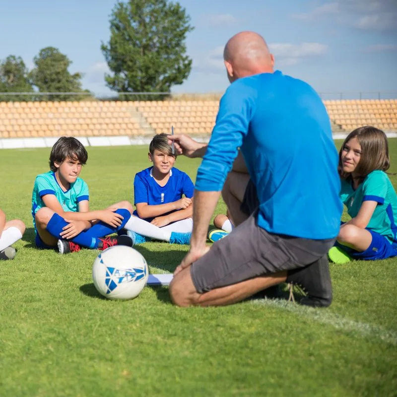 Voetbaltrainer geeft training op het veld